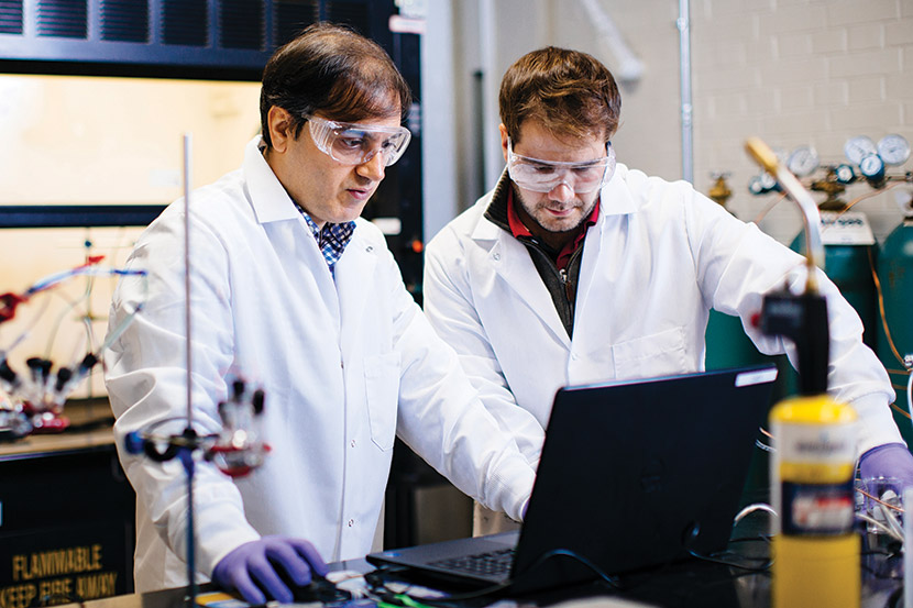 A graduate faculty member working with a student inside an engineering lab