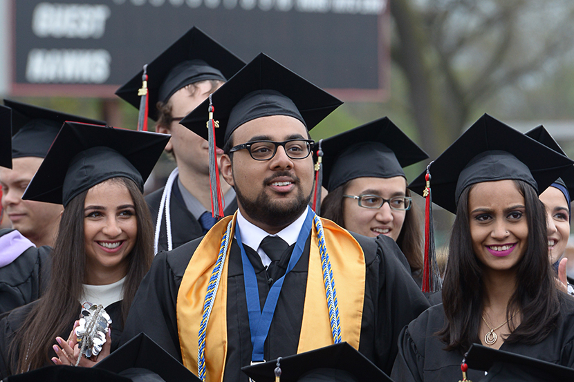 A photo of undergraduate students at a commencement ceremony outdoors