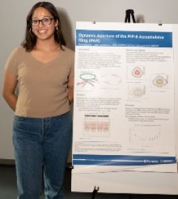 Applied mathematics students with a poster displaying her research