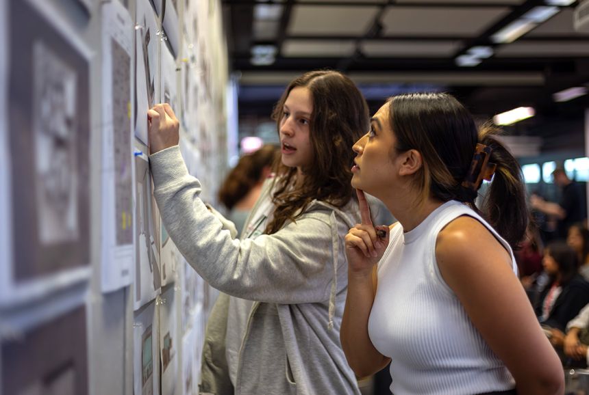 An Experiment in Architecture summer program participant examines a design with an instructor in July 2023