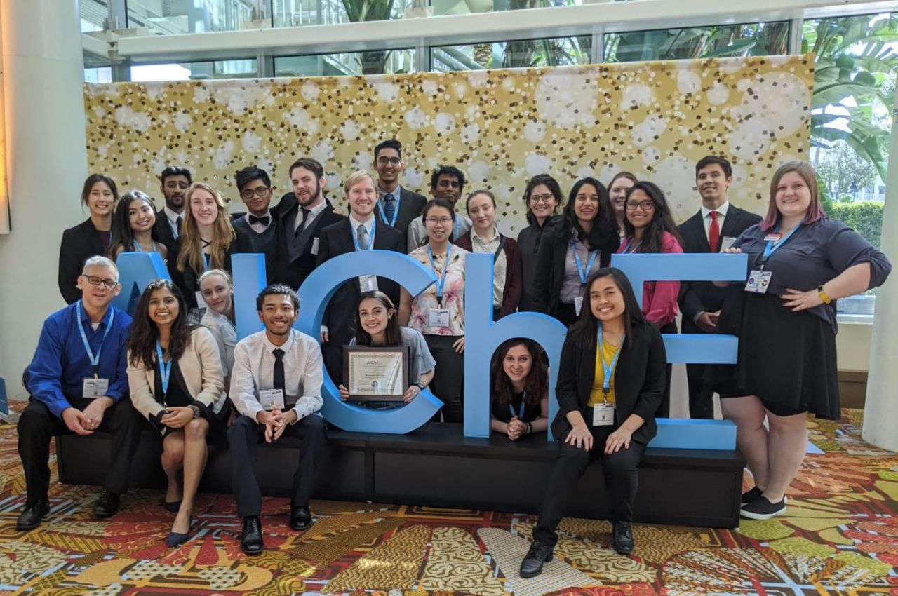 Group photo of members of the Illinois Tech chapter of AIChE with AIChE sign