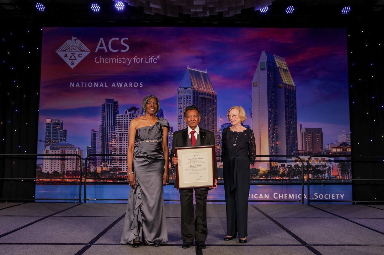 Adjunct Faculty Bipin Vora (middle) holding the George A. Olah Award on stage at the awards ceremony in San Diego.
