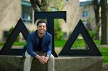 Photo of Shahaan Mirza Mirza (ITM/M.A.S. TENR ’25) sitting in front of the Delta Tau Delta fraternity.