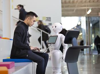 A student in Kaplan programs a robot