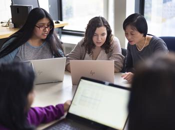 ACM - Association for Computing Machinery - photo of students and faculty at work on laptop computers