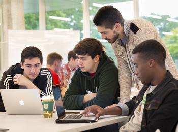 Kaplan - IPRO - Interprofessional Projects - photo of students collaborating around computers