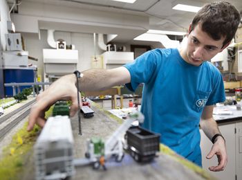 A model railroad club organizer sets up a track at Illinois Tech