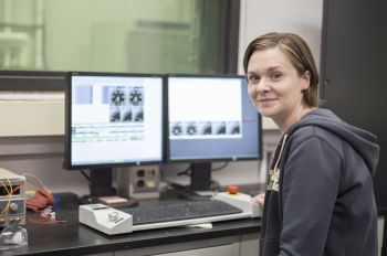 Carrie Hall sitting at a desk with computer screens displaying dials