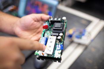 Electrical engineering student holds circuit board