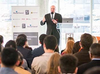 A speaker presents during a Kaplan Institute event