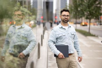 Student Edgar stands in front of Stuart School of Business. 