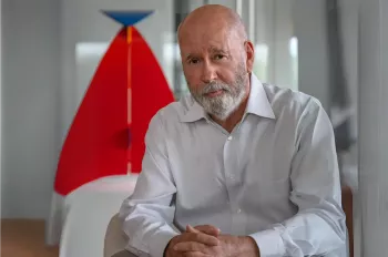 David Hovey Sr Honorary Doctor of Architecture awardee sitting in front of artwork