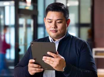 Illinois Tech Business Analytics student holding ipad