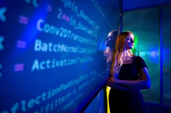 An Illinois Tech student stands next to code