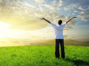 Person experiencing bliss on hillside with sunny skies