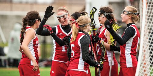 Women's lacrosse team giving each other a high five