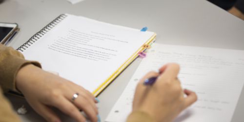 A student takes notes in a Lewis College class