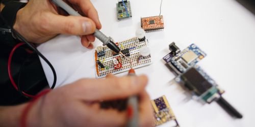 A researcher works to built a circuitboard 