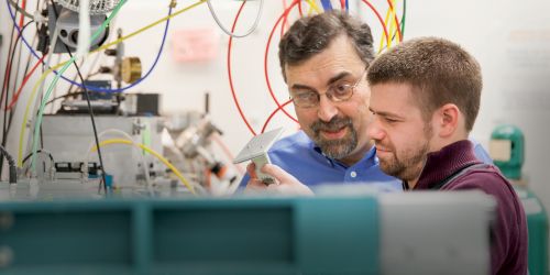 A faculty member working with a student in a lab