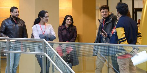 Multiple students talking along a hallway