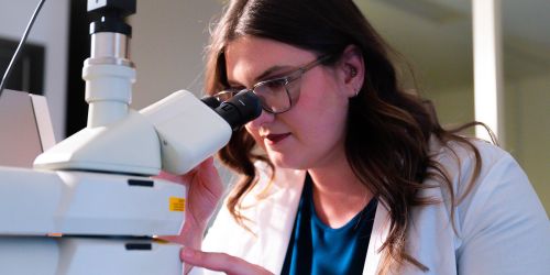 An Illinois Tech student works on a microscope