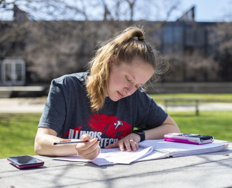 A student does homework outdoors