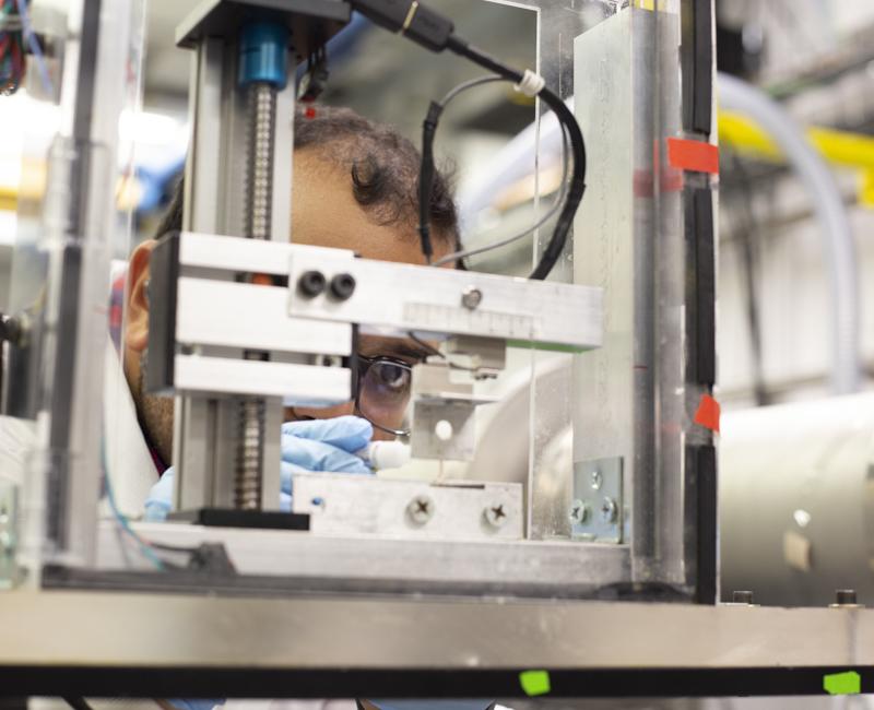 A graduate student researcher places a tissue sample for analysis