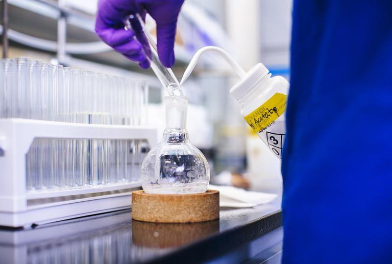 A researcher mixes compounds in a chemistry lab