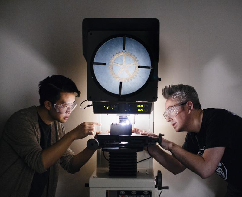 Two students examine a gear in a materials lab