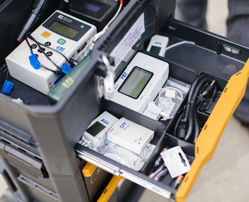 A tray of instruments sits in a cart in a lab space