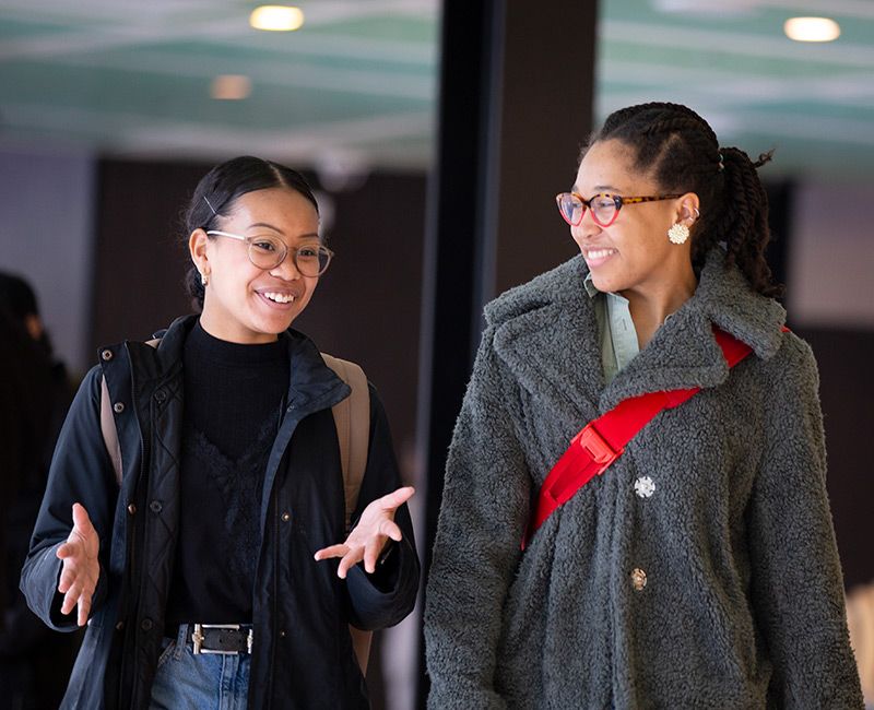 two students walking and talking at MTCC bridge