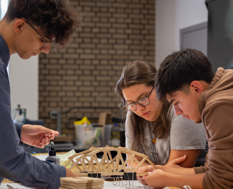 Three summer school students working on model inside